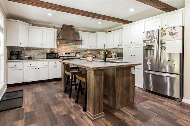 5618 Bowen Rd, Blackshear, GA 31516 - kitchen with appliances with stainless steel finishes, premium range hood, beam ceiling, white cabinetry, and dark wood-style flooring