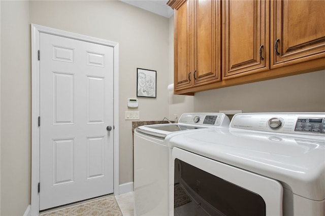 laundry area with light tile patterned flooring, cabinets, and washing machine and clothes dryer