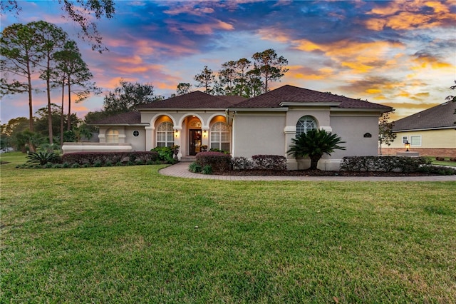 mediterranean / spanish home featuring a lawn