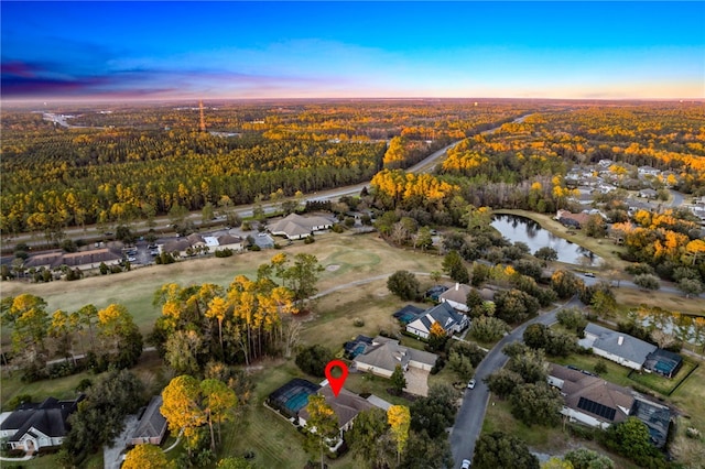 aerial view at dusk featuring a water view