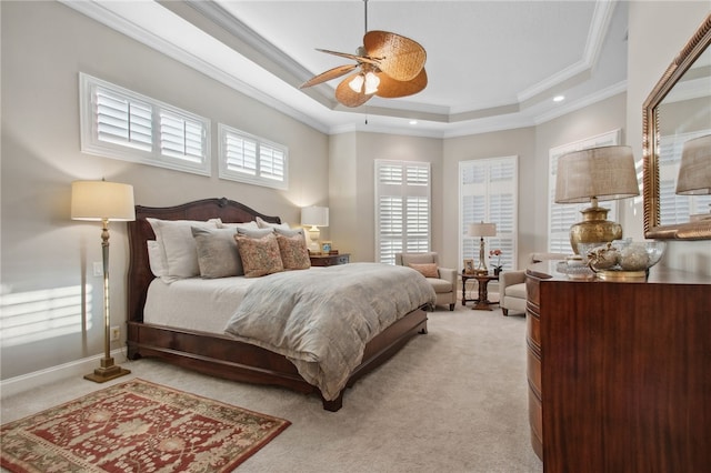 carpeted bedroom featuring ceiling fan, ornamental molding, and a tray ceiling