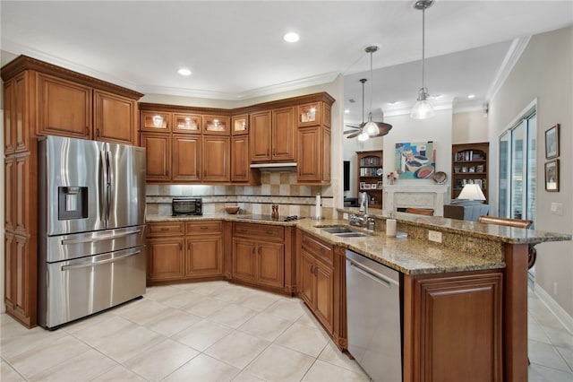 kitchen featuring appliances with stainless steel finishes, tasteful backsplash, ceiling fan, sink, and decorative light fixtures