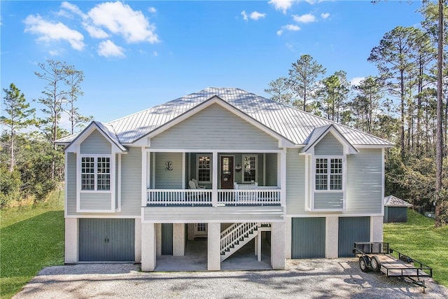 view of front of home featuring a garage, a front yard, and covered porch