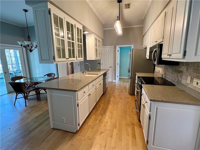 145 Shore Rush Dr, Saint Simons Island, GA 31522 - kitchen with ornamental molding, appliances with stainless steel finishes, a chandelier, white cabinets, and backsplash