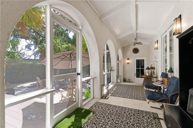 sunroom / solarium featuring ceiling fan and lofted ceiling with beams