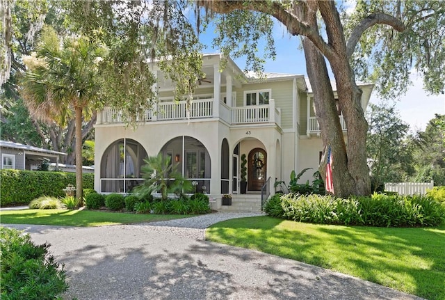 view of front of house with a front yard and a balcony