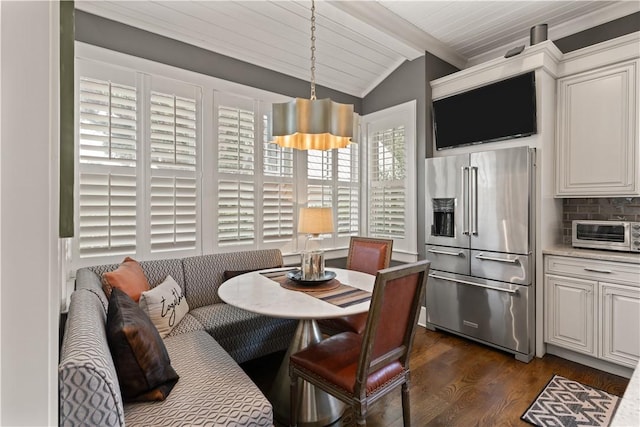 dining room featuring breakfast area, vaulted ceiling with beams, dark hardwood / wood-style floors, and wood ceiling