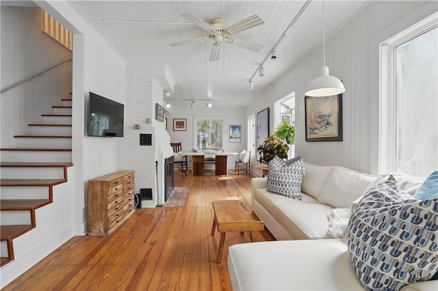 4206 Tenth St, Saint Simons Island, GA 31522 - living room with rail lighting, light wood-style flooring, stairs, and ceiling fan