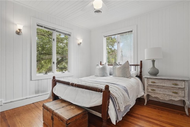 4206 Tenth St, Saint Simons Island, GA 31522 - bedroom with wood-type flooring, multiple windows, a baseboard radiator, and crown molding