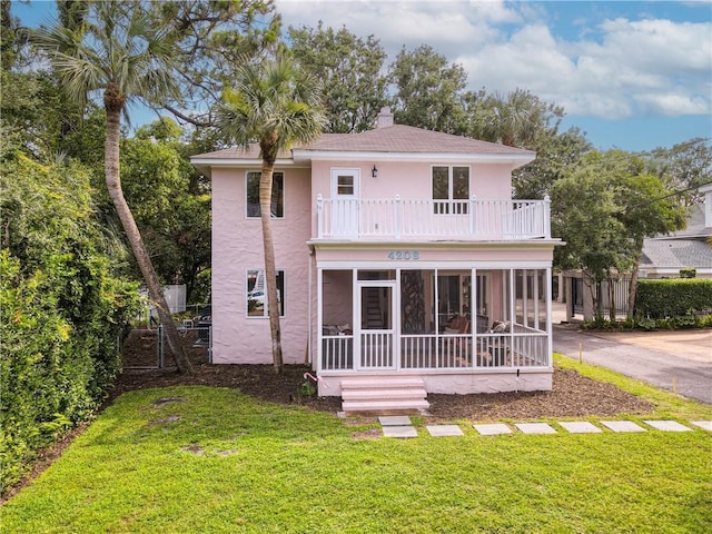 4206 Tenth St, Saint Simons Island, GA 31522 - rear view of property featuring a balcony, stucco siding, a sunroom, and a shingled roof