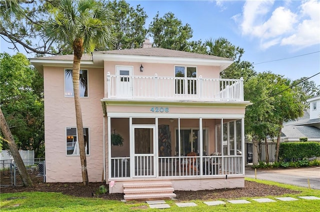 4206 Tenth St, Saint Simons Island, GA 31522 - view of front of home featuring a balcony, a sunroom, and stucco siding