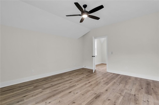 spare room with ceiling fan, baseboards, wood finished floors, and vaulted ceiling