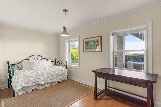 bedroom featuring wood-type flooring, crown molding, and multiple windows