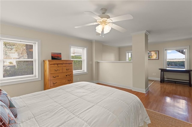 bedroom with hardwood / wood-style floors, ceiling fan, and ornamental molding