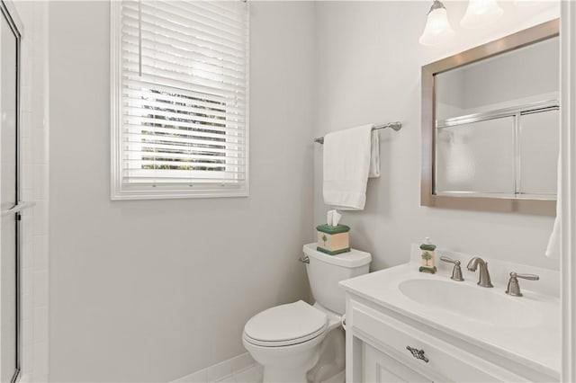 bathroom with vanity, a shower with shower door, and toilet