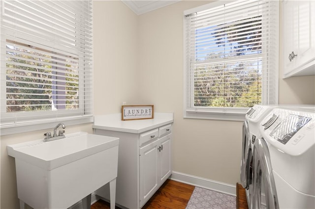 clothes washing area featuring sink, cabinets, dark hardwood / wood-style flooring, washer and dryer, and ornamental molding