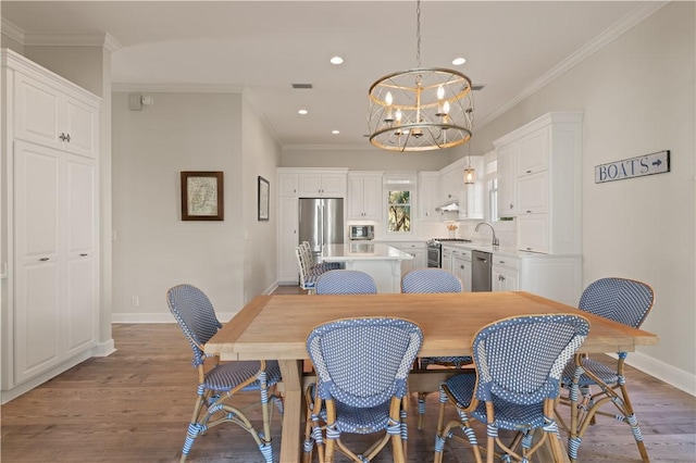 dining room featuring ornamental molding, a notable chandelier, and hardwood / wood-style flooring