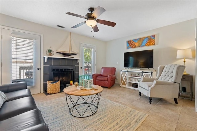 living room with a fireplace, light tile patterned floors, and plenty of natural light