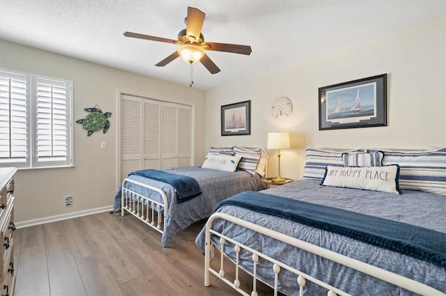 bedroom featuring ceiling fan, light hardwood / wood-style floors, a closet, and a textured ceiling