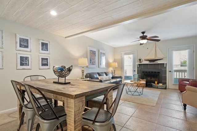 dining space featuring light tile patterned floors, a fireplace, wooden ceiling, and ceiling fan