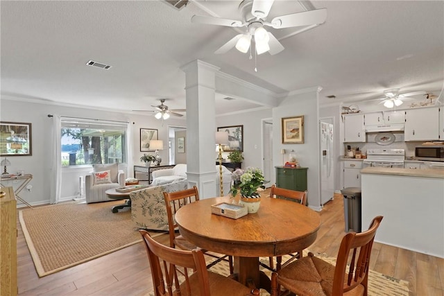 1152 Julienton Lndg NE, Townsend, GA 31331 - dining room with a ceiling fan, light wood-style floors, ornate columns, and ornamental molding