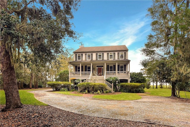 colonial-style house with covered porch and a front lawn