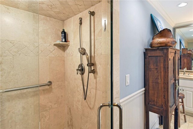 details featuring sink, a shower with door, and ornamental molding