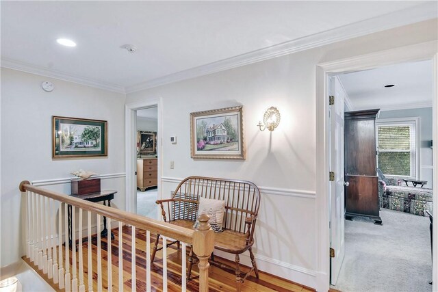 corridor with light hardwood / wood-style flooring and ornamental molding