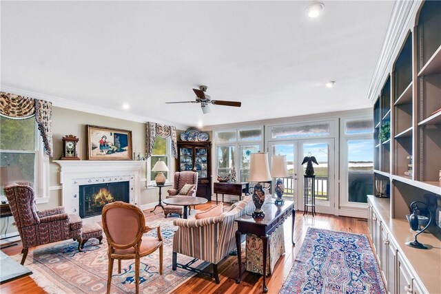 living room featuring crown molding, french doors, ceiling fan, and light hardwood / wood-style floors