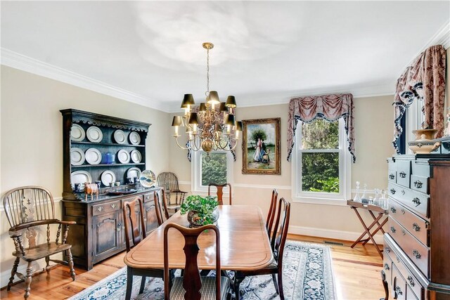 dining area featuring light wood-type flooring, an inviting chandelier, and ornamental molding