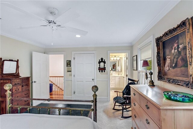 carpeted bedroom with crown molding, ceiling fan, and ensuite bathroom