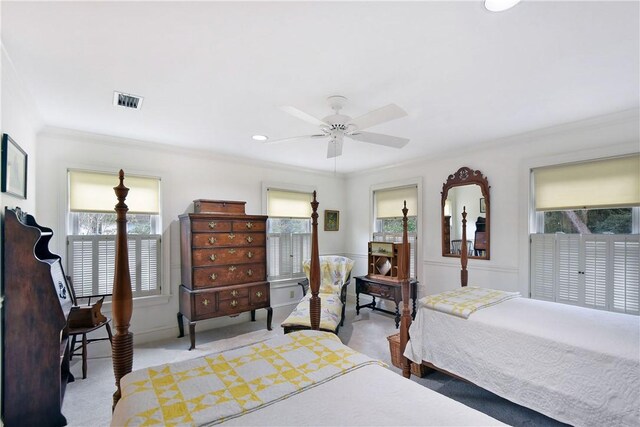 carpeted bedroom with ceiling fan and ornamental molding