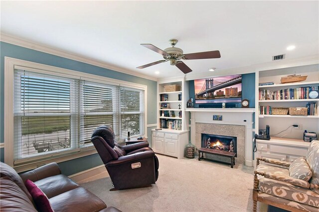 carpeted living room featuring built in features, ceiling fan, and ornamental molding