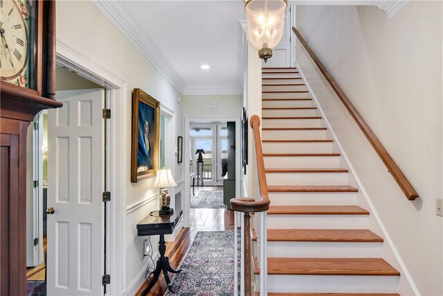 stairway featuring wood-type flooring and ornamental molding