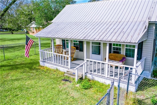 back of property featuring covered porch and a lawn