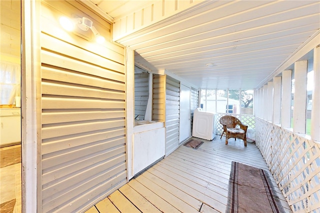 wooden deck with washer and dryer and a porch