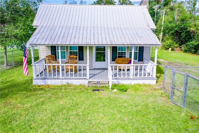 back of property featuring a yard and covered porch