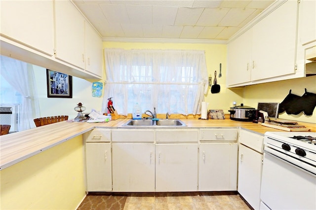 kitchen with white cabinets, crown molding, white range, and sink