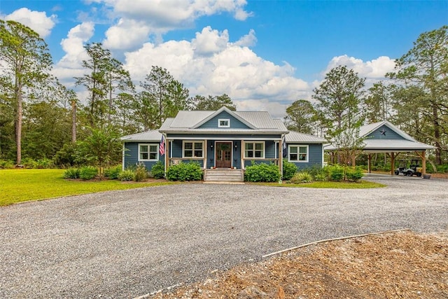 view of front of property with covered porch, a carport, and a front yard