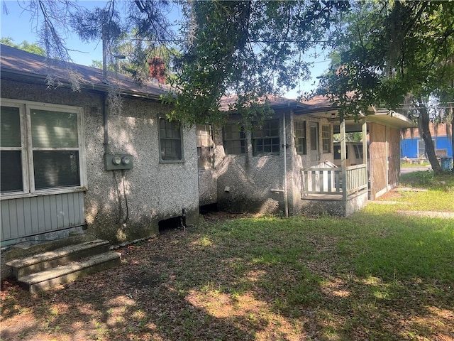 3228 Reynolds St, Brunswick, GA 31520 - rear view of property featuring covered porch, a chimney, and stucco siding
