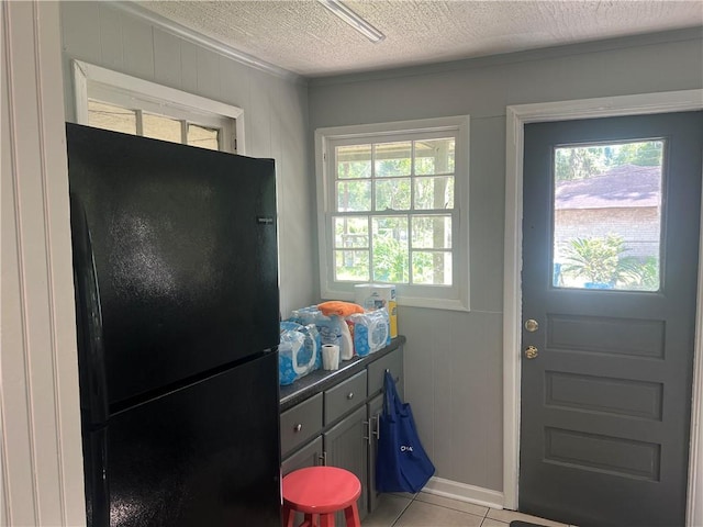 3228 Reynolds St, Brunswick, GA 31520 - doorway to outside featuring a textured ceiling, light tile patterned flooring, and baseboards