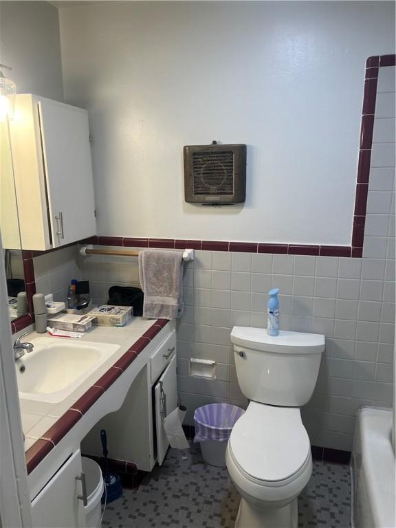 3228 Reynolds St, Brunswick, GA 31520 - bathroom with tile walls, toilet, vanity, a tub to relax in, and wainscoting