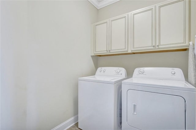 washroom with cabinets, washing machine and dryer, and ornamental molding