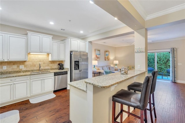 kitchen with dark hardwood / wood-style flooring, sink, white cabinets, and stainless steel appliances