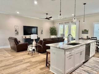 kitchen featuring pendant lighting, sink, white cabinetry, an island with sink, and stainless steel dishwasher