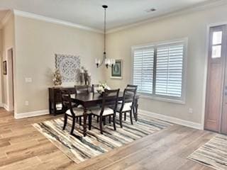 dining space with crown molding, wood-type flooring, and plenty of natural light