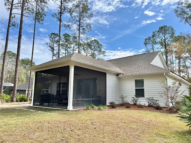 rear view of house with a sunroom and a lawn