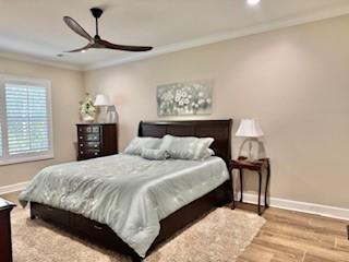 bedroom with crown molding, ceiling fan, and light wood-type flooring