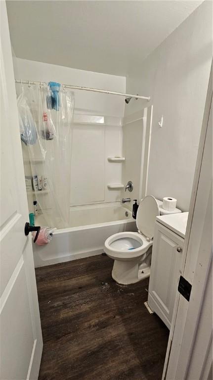 bathroom with shower / bathtub combination with curtain, wood finished floors, toilet, and vanity