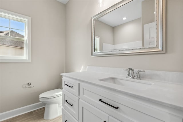 bathroom featuring hardwood / wood-style flooring, toilet, and vanity